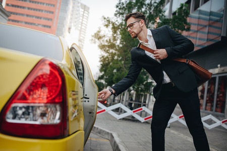 Businessman boarding a taxi to commute of office