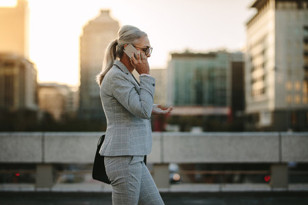 Senior businesswoman using cellphone on city street