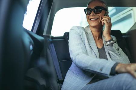 Business woman using phone inside the car