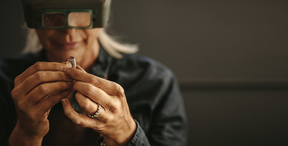 Jeweler inspecting diamond ring with magnifying glass