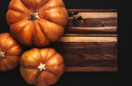 Halloween flat lay of pumpkins on wooden board