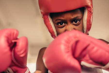 Close up of kid in boxing gloves and head guard