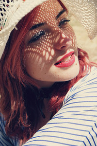 Young redhead woman covering from sun