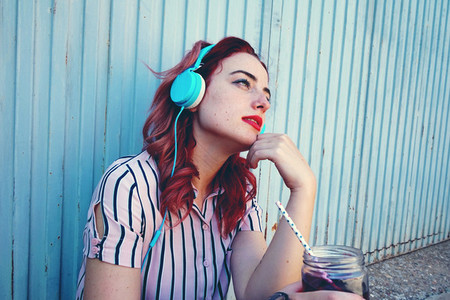 Beautiful redhead woman listening to music