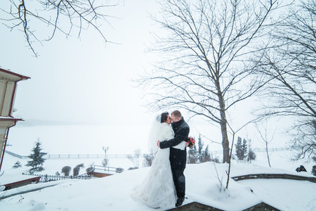 Bride and groom walking on the European city in the snow
