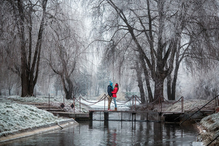 Couple in winter forest near lake