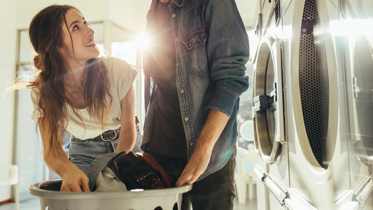 Couple doing laundry together picking clothes from a basket