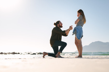 Man making a marriage proposal to woman at beach