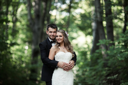 Beautiful wedding couple posing in forest