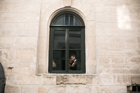 Wedding couple kissing in the window