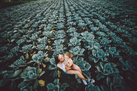Mother and daughter on the field with cabbage