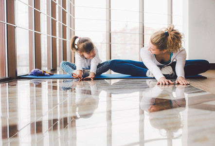 Mother and daughter makeing yoga in the gym