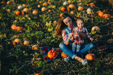 mother and daughter on a field with pumpkins
