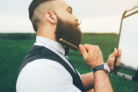 bearded man preparing to shave in the field