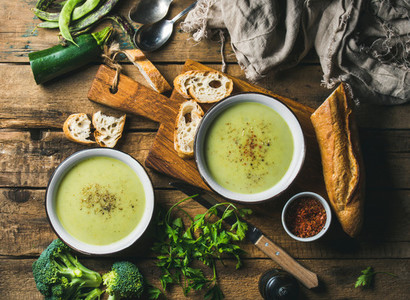 Two bowls of homemade pea  broccoli and zucchini cream soup