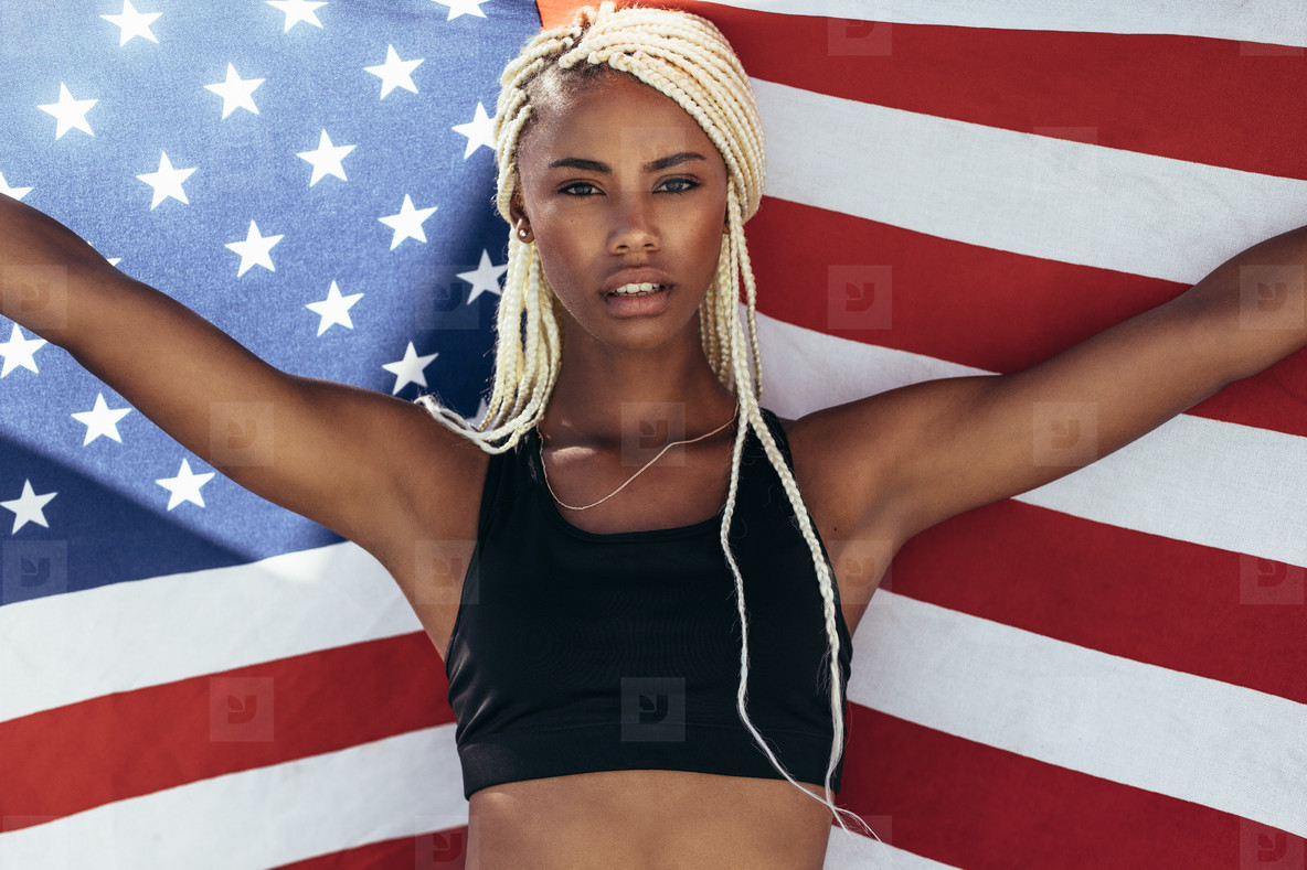 Female athlete holding american flag behind her