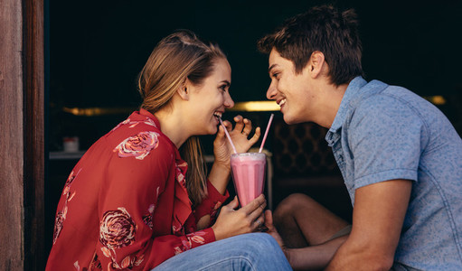 Romantic couple sharing a milkshake