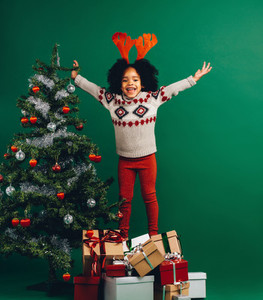 Excited kid standing on gift boxes