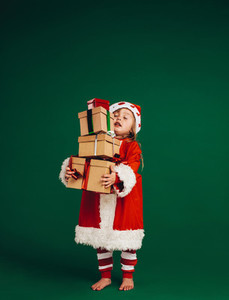 Kid dressed as santa carrying gifts