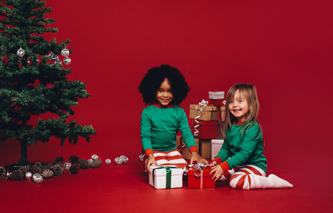 Kids sitting with their christmas gifts