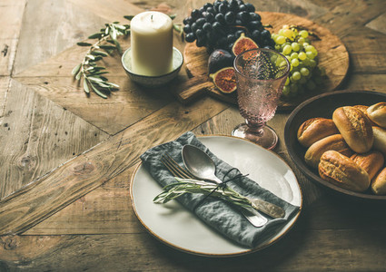 Plate with linen napkin fork spoon glass candle fruits
