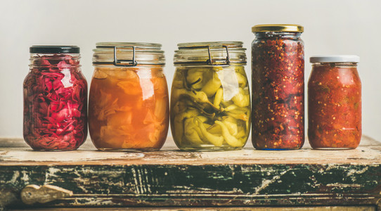 Autumn pickled colorful vegetables in jars placed in line