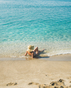 Senior woman tourist in bikini lying at clear sea waters