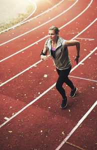 Young active sportswoman running on stadium