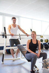 Couple Smiling at Camera After Barbell Exercise