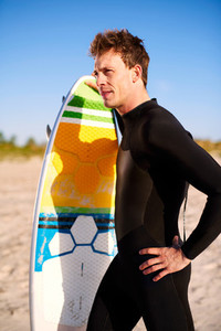 Athletic fit young surfer with his surfboard