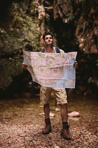 Hiker using a map to find the route to the destination