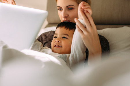 Mother and son enjoying watching cartoon movie on laptop