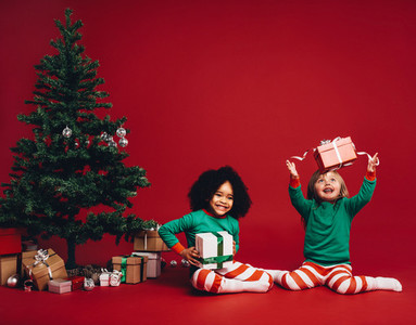 Children playing with christmas gift boxes