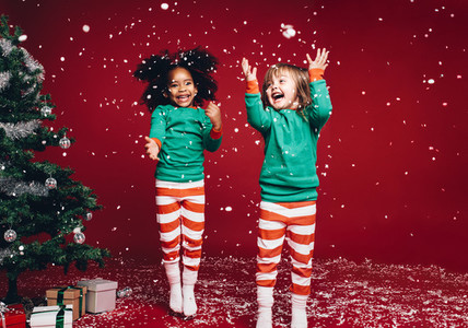Little girls playing with artificial snow flakes
