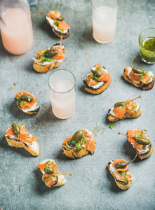 Crostini with smoked salmon and grapefruit cocktails in glasses