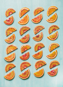 Fresh juicy blood orange slices placed in rows  blue background