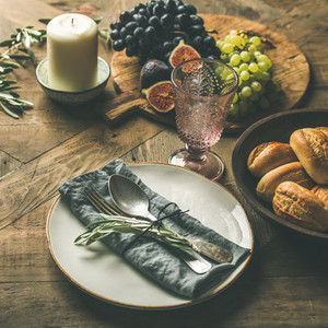 Plate with linen napkin  fork  spoon  glass  candle  fruits  bread