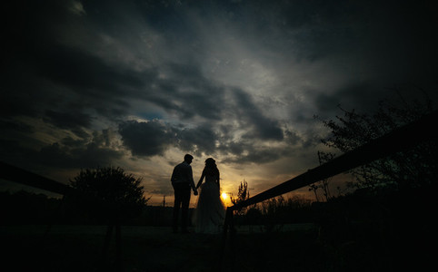 Silhouette of  wedding couple in field