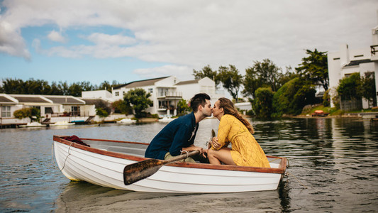 Couple on a date kissing in a boat