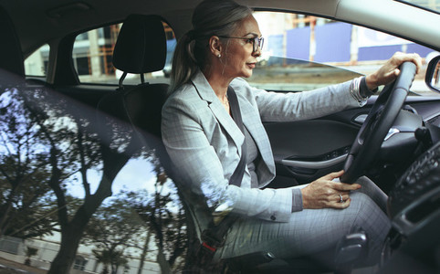 Senior businesswoman driving to office in a car
