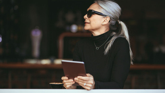 Mature woman at a coffee shop with tablet pc