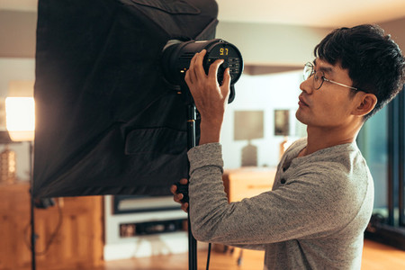 Photographer adjust softbox light intensity for shoot