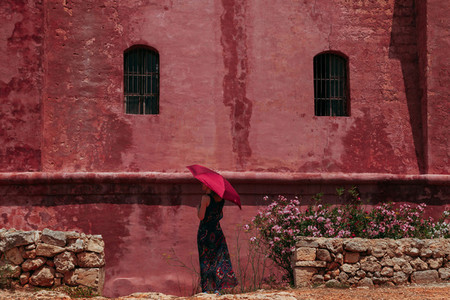 Young lonely woman with a red umbrella