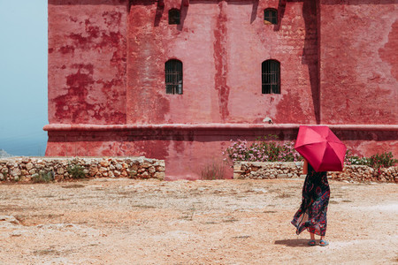 Young lonely woman with a red umbrella