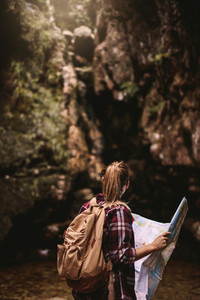 Female hiker with map looking away