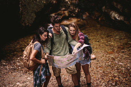 Friends using a map to find the route while hiking