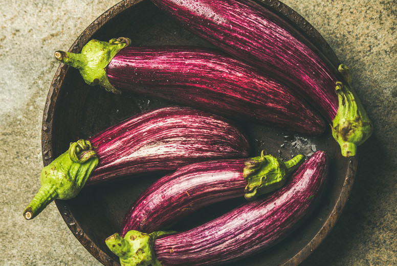Flat-lay of fresh raw Fall harvest purple eggplants, square crop