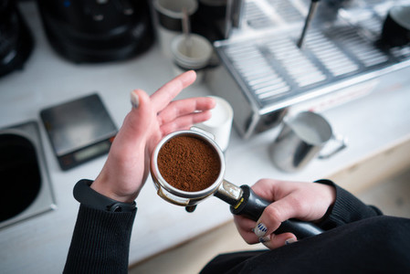 Barista holding portafilter with ground coffee