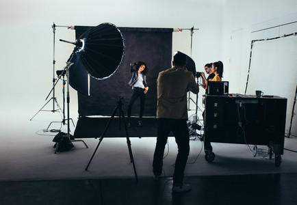 Photographer with his crew during a photo shoot in studio
