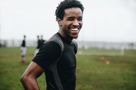 Close up of a smiling soccer player standing on field